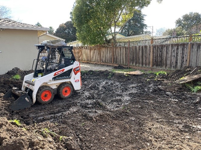 Final grading crew on residential backyard lot